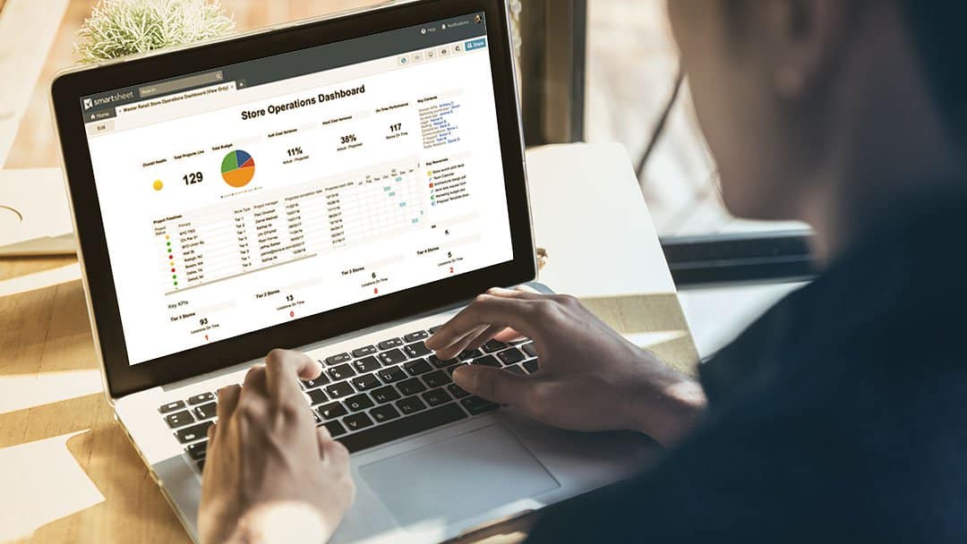 A man views a store operations dashboard on Smartsheet