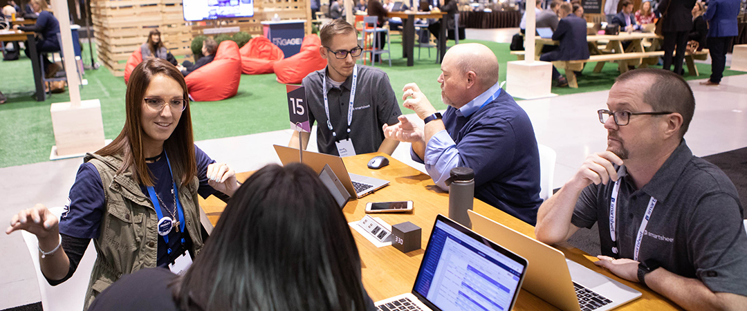 A full-color group shot of men and women sitting around a table engaged in discussion