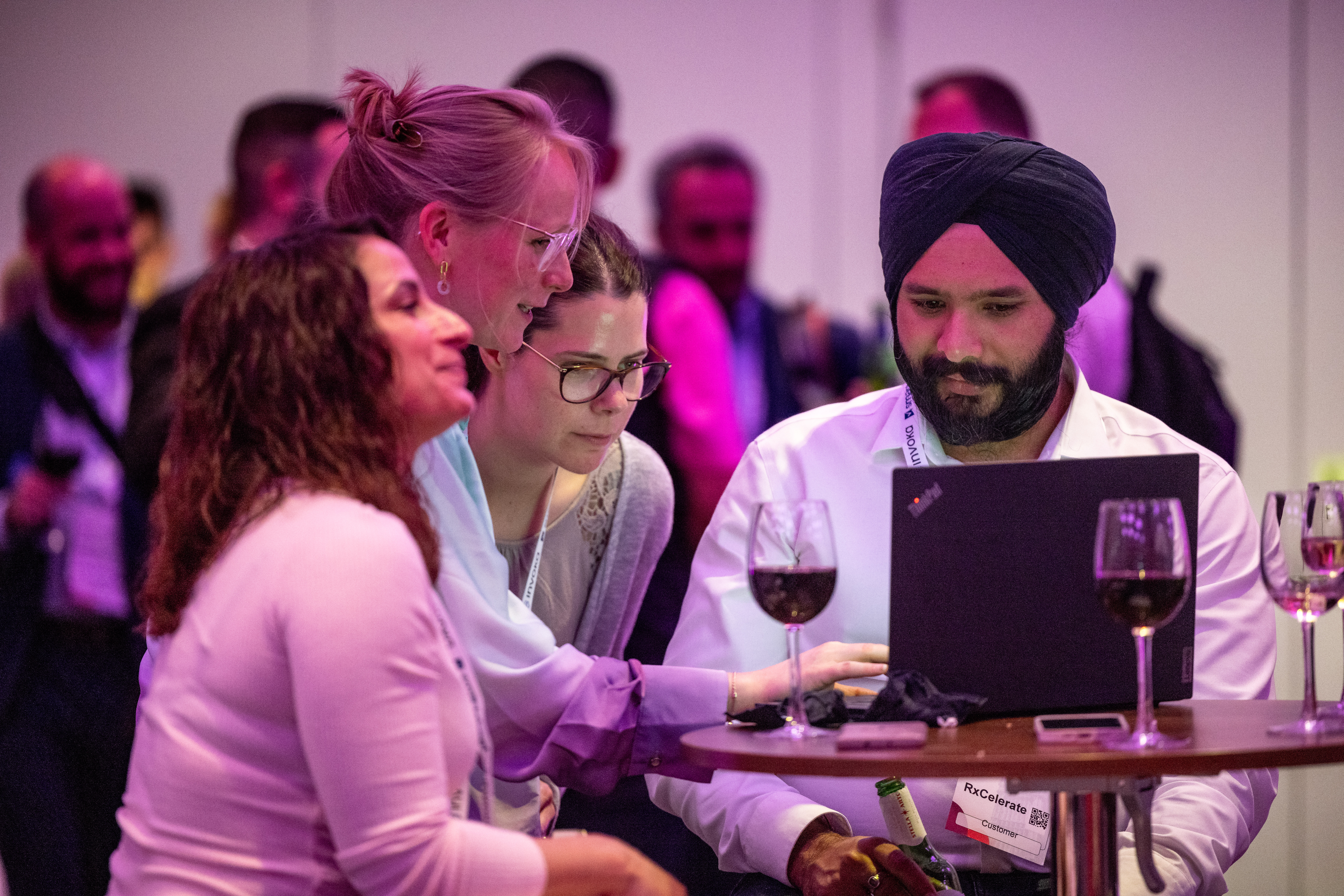 Attendees at Smartsheet ENGAGE in London chat over wine during the attendee reception.